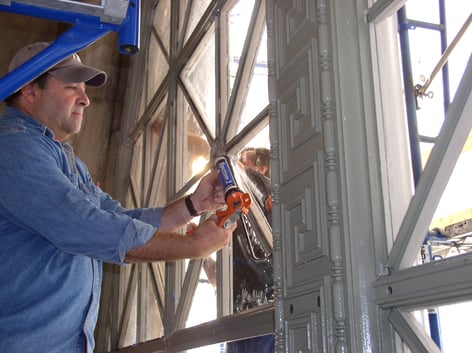 Installer applying sealant to window